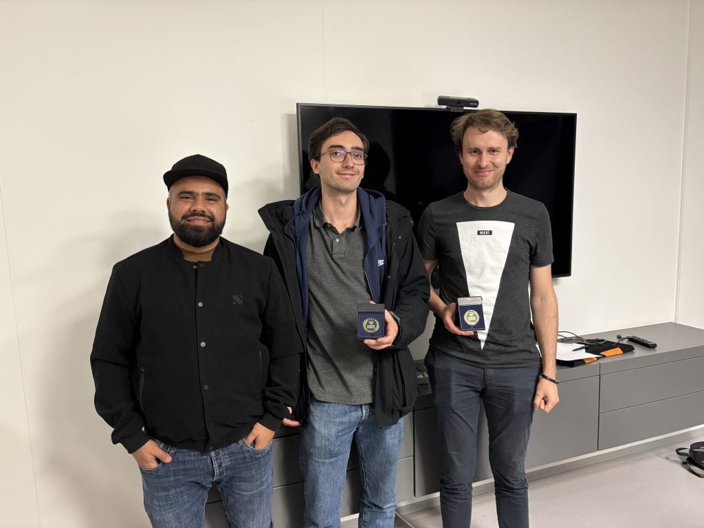 Participants of the usd Hackertage and usd Hacking Night present their awards in front of a screen in a modern conference room.