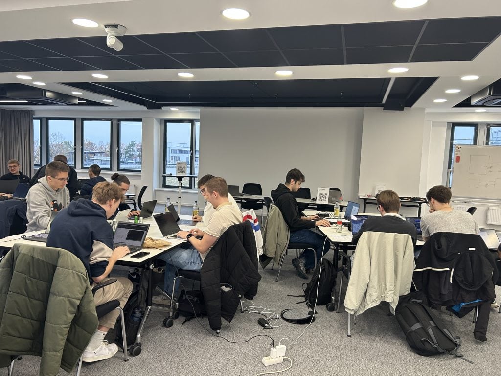 Teilnehmer*innen der usd Hackertage am Standort Neu-Isenburg arbeiten in einem modernen Schulungsraum an Laptops, um Cybersecurity-Aufgaben und Hacking-Challenges zu lösen.